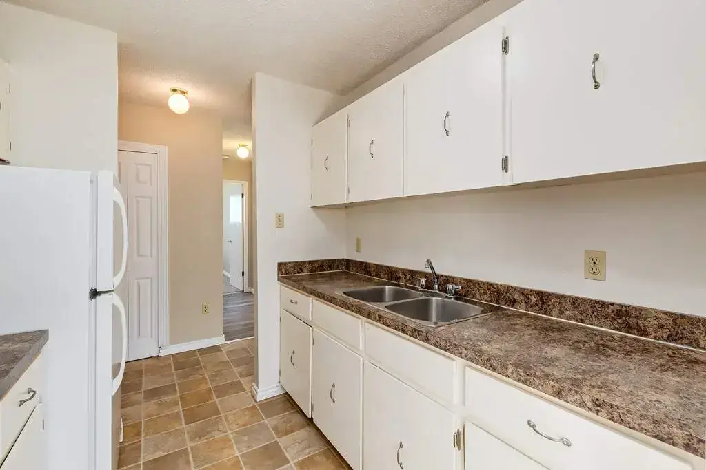 Galley style kitchen with appliances at Lamplighter in Camrose.