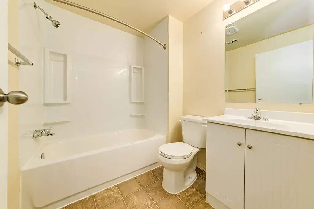 Bright full bathroom with tub and shower at Spruce View Apartments in Camrose.