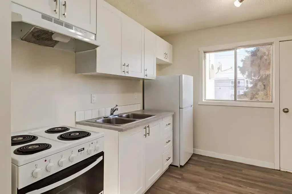 Charming compact kitchen with cabinets, countertop workspace, and practical layout at Aiva Manor.