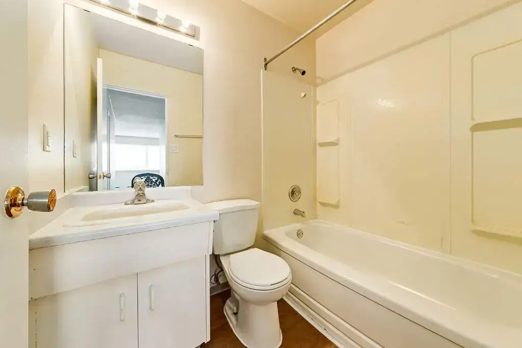 Functional full bathroom with tub and shower at Cloverdale Apartments in Edmonton.
