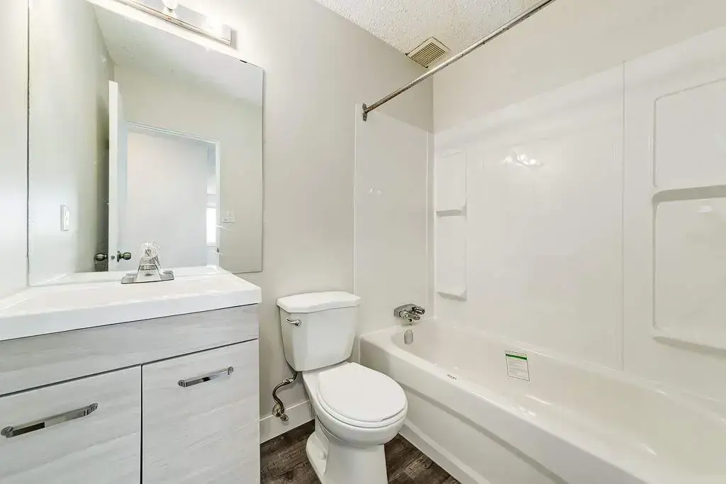 Functional full bathroom with tub and shower at Cloverdale Apartments in Edmonton.