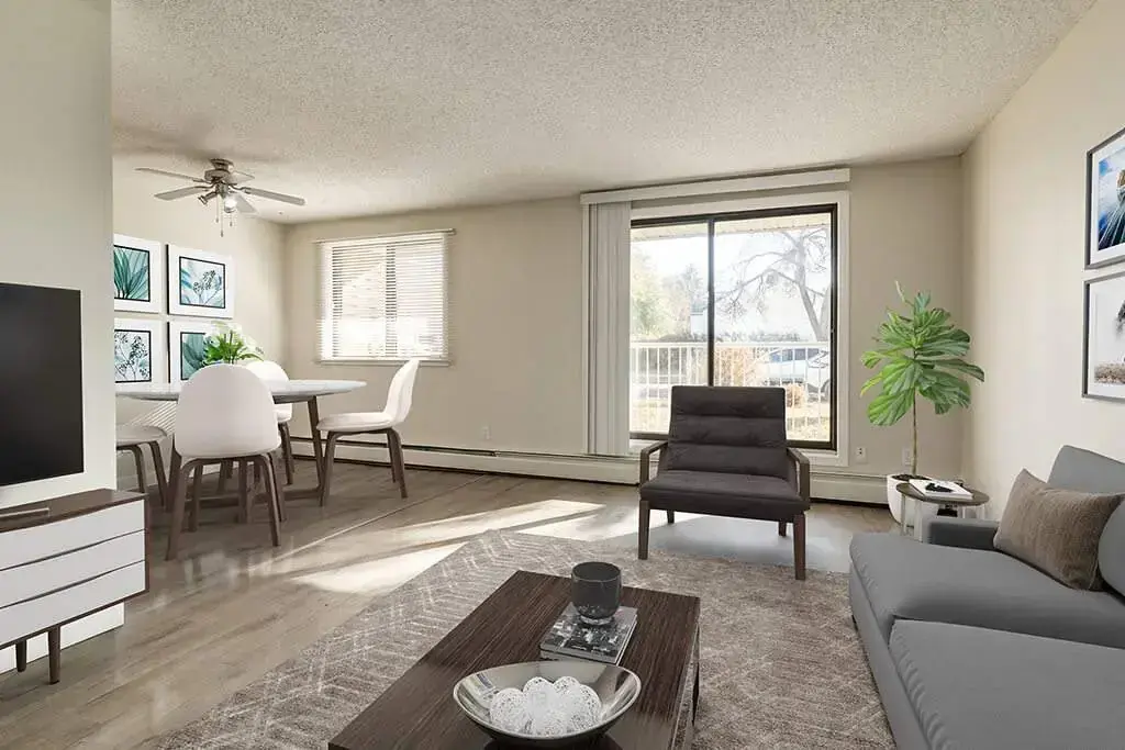 Sunlit living room with large windows at Hudson Court in Edmonton.