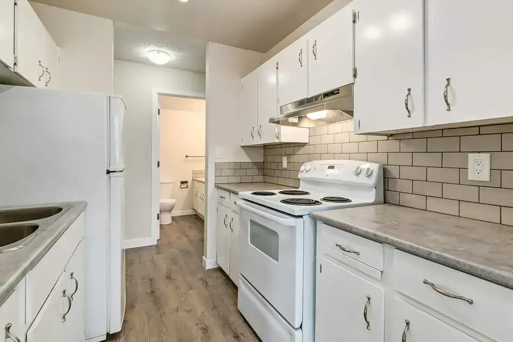 Galley style kitchen with appliances at Hudson Court in Edmonton.