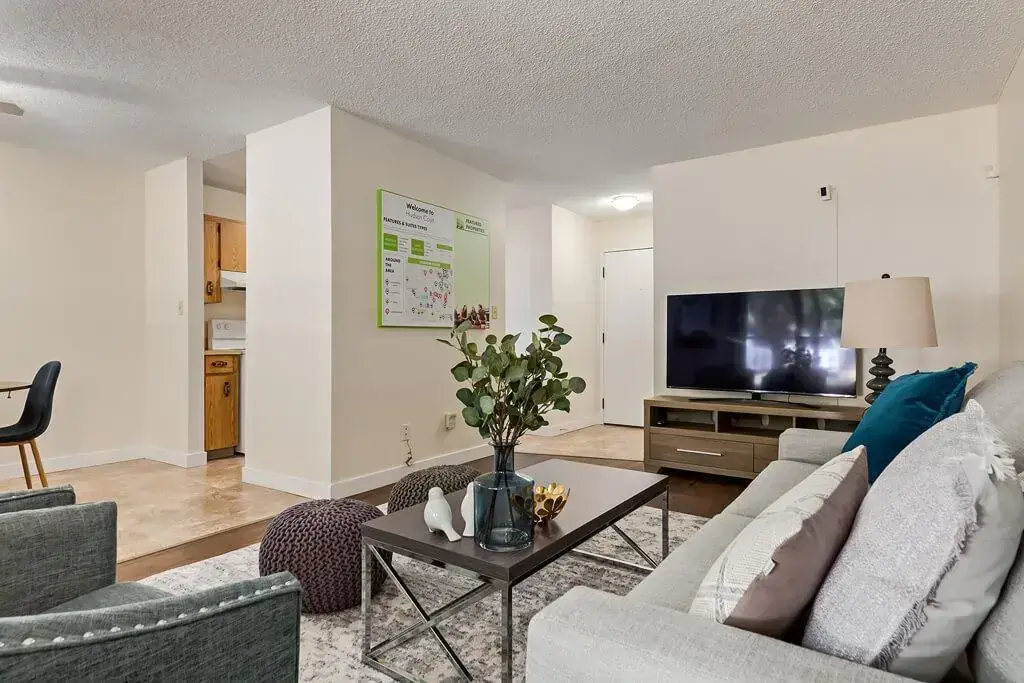 Airy living room with bright windows at Hudson Court in Edmonton.