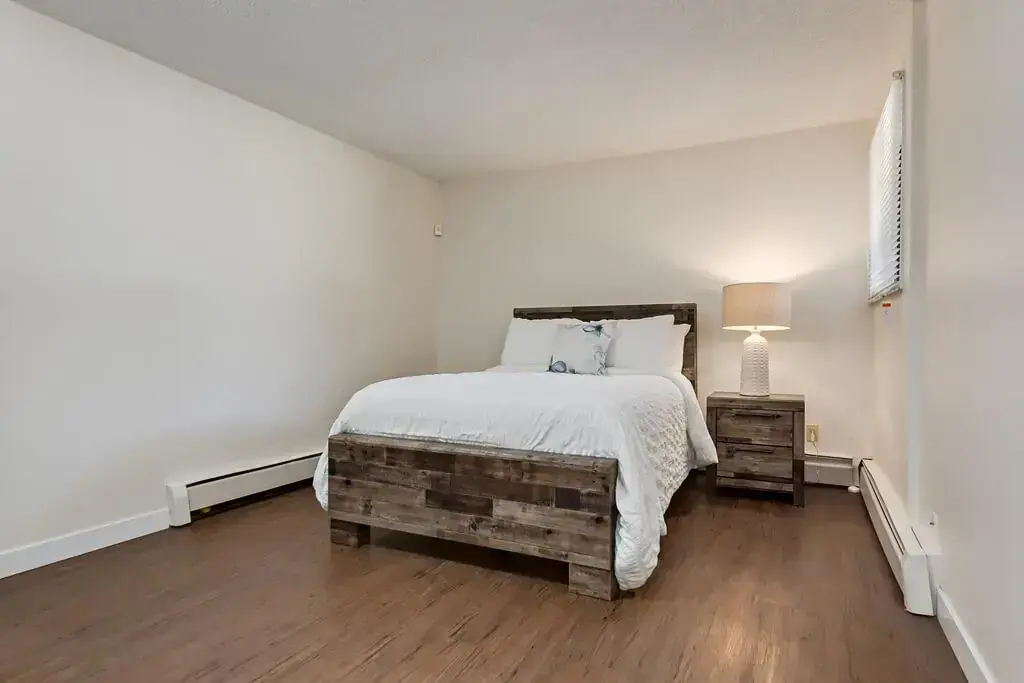 Bright bedroom with comfortable proportions at Hudson Court in Edmonton.