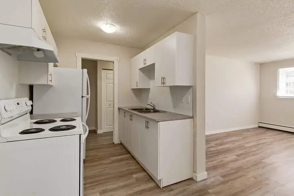 Galley style kitchen with appliances at Lenita Manor in Edmonton.