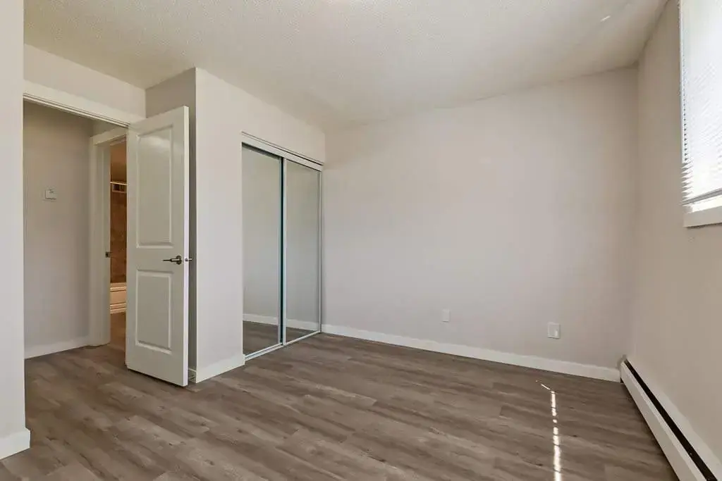 Open bedroom space with flexible layout at Lenita Manor in Edmonton.