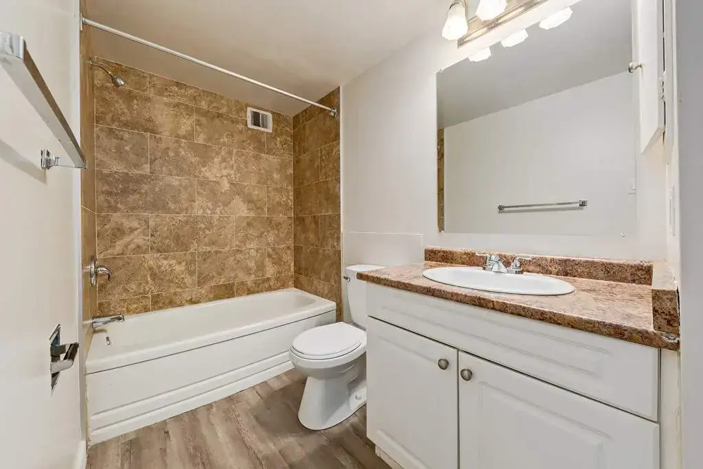 Clean full bathroom with tub and shower at Lenita Manor in Edmonton.