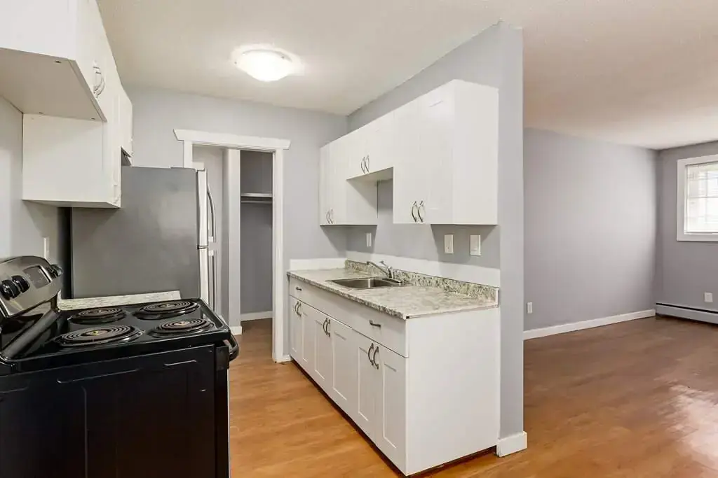 Well-appointed kitchen with stainless steel fridge and stove at Lenita Manor in Edmonton.