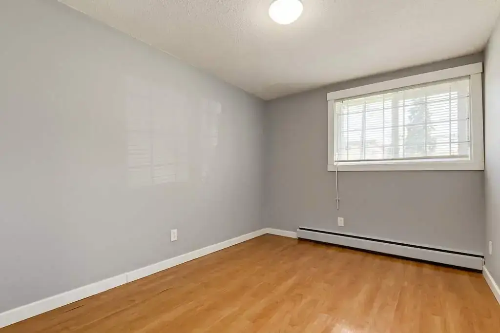 Open bedroom space with flexible layout at Lenita Manor in Edmonton.