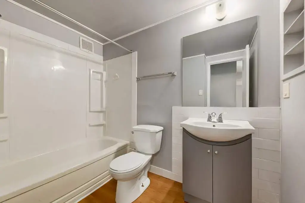 Clean full bathroom with tub and shower at Lenita Manor in Edmonton.
