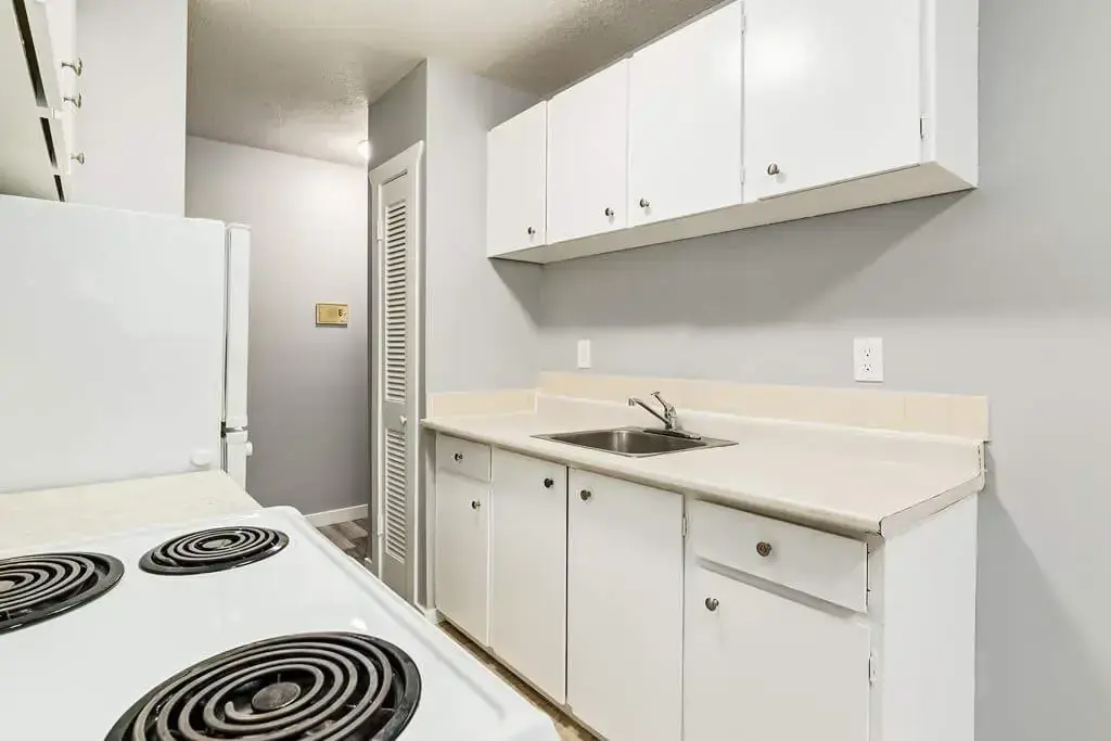 Galley style kitchen with appliances at Linda Manor in Edmonton.