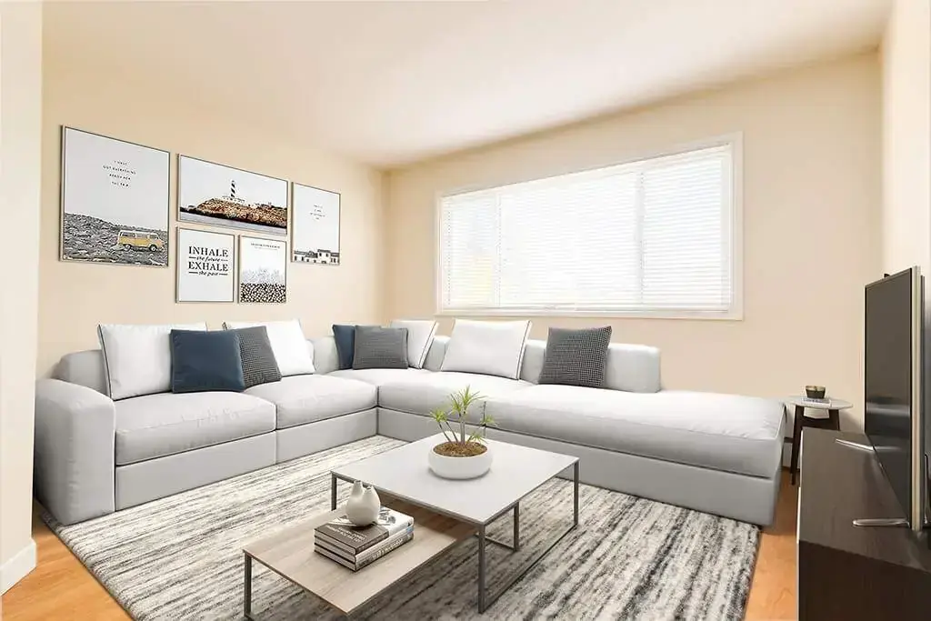 Sunlit living room with large windows at Skyview Apartments in Edmonton.