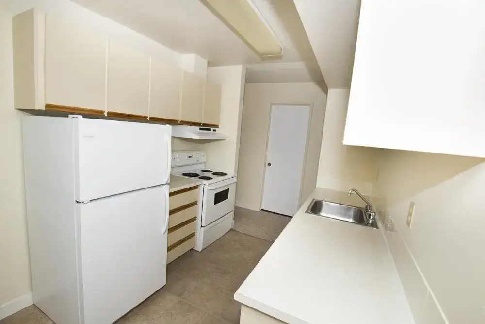 Galley style kitchen with appliances at South Ridge Apartments in Edmonton.