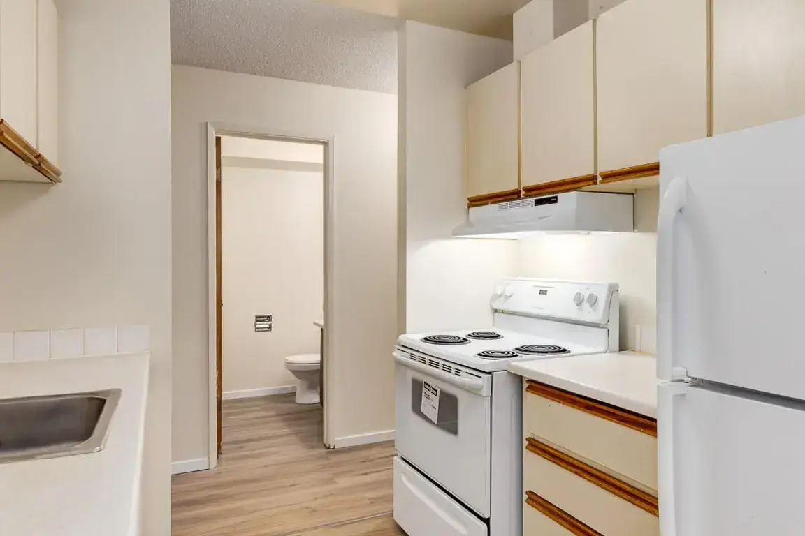 Galley style kitchen with appliances at South Ridge Apartments in Edmonton.
