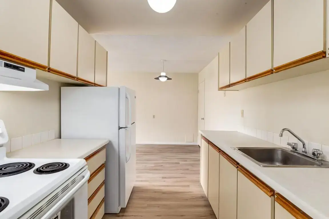Galley style kitchen with appliances at South Ridge Apartments in Edmonton.