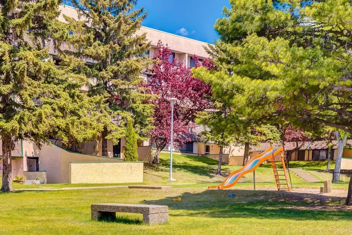 Well-maintained green area and playground at South Ridge Apartments in Edmonton.