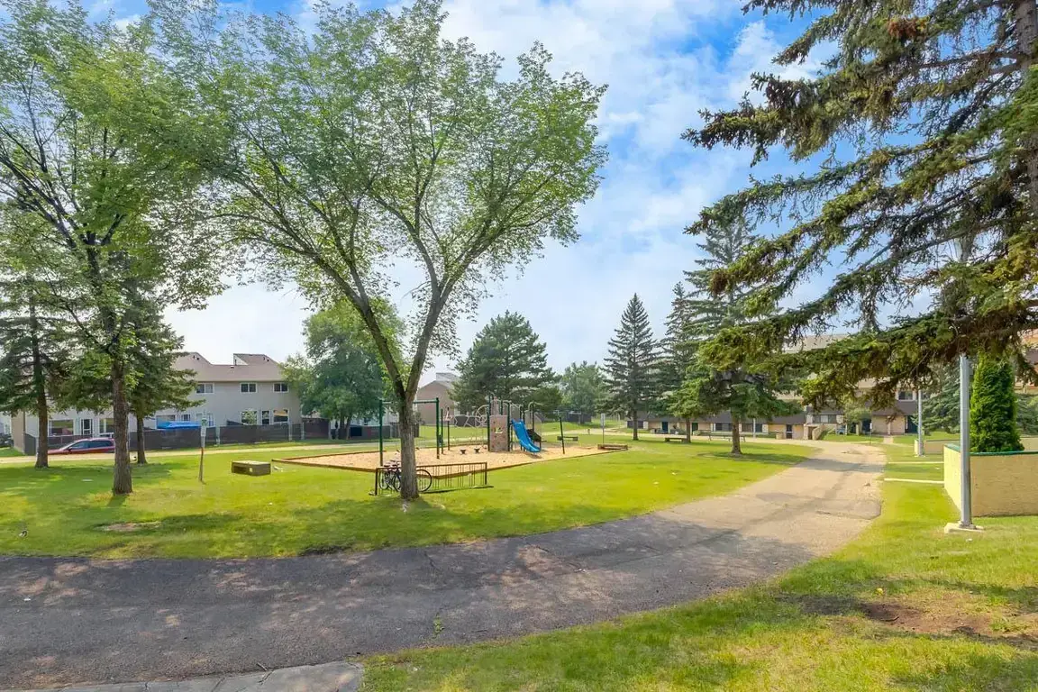 Well-maintained green area and playground at South Ridge Apartments in Edmonton.