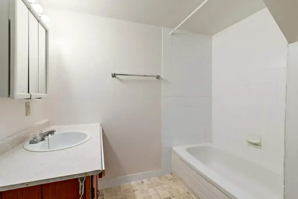 Full bathroom with tub and shower at Bel-Aire Apartments in Lethbridge.