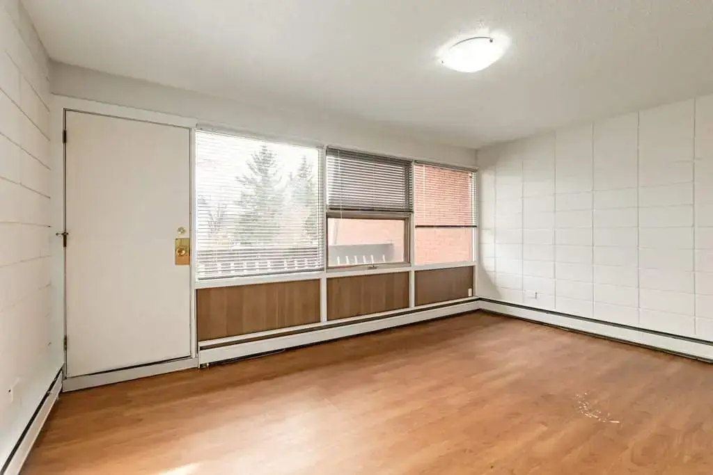 Bright living room with large window at Bel-Aire Apartments in Lethbridge.