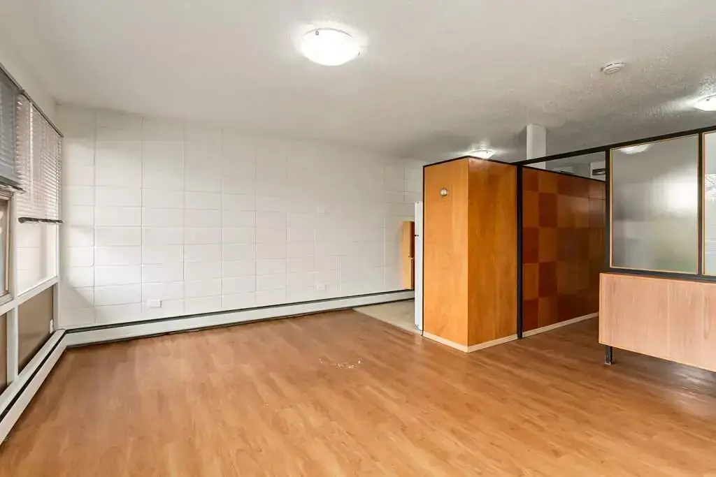 Airy living room with bright windows at Bel-Aire Apartments in Lethbridge.