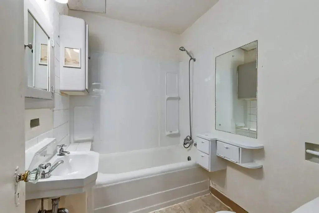 Apartment bathroom with tub and shower at Tudor Manor in Lethbridge.