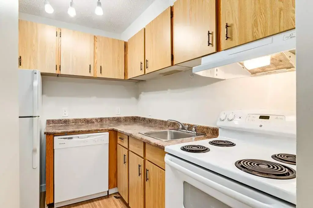 Well-appointed kitchen with fridge, dishwasher and stove at Cambridge Court in Lloydminster.