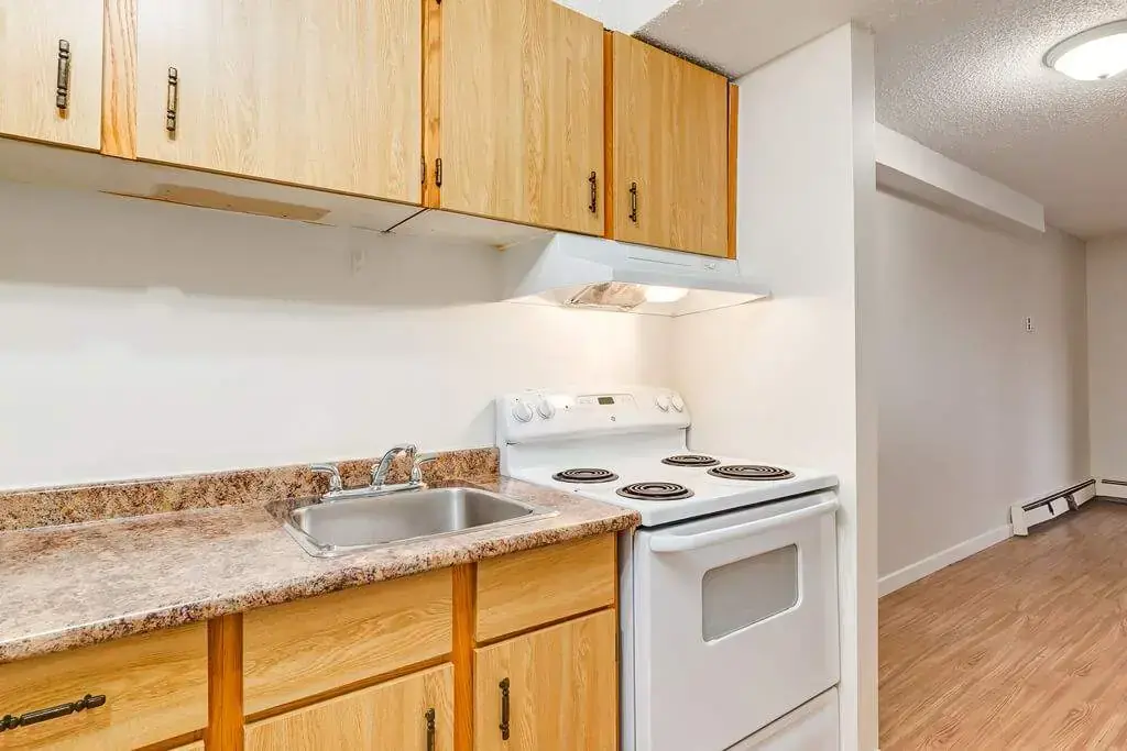 Well-appointed kitchen with fridge, dishwasher and stove at Cambridge Court in Lloydminster.