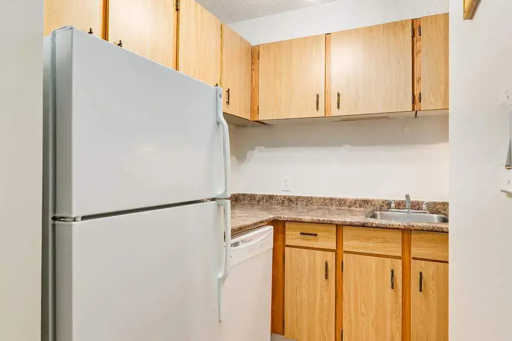 Well-appointed kitchen with fridge, dishwasher and stove at Cambridge Court in Lloydminster.