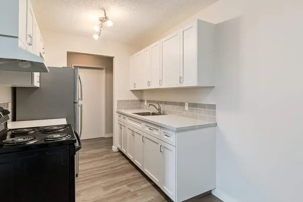 Galley style kitchen with appliances at Hillview Apartments in Medicine Hat.
