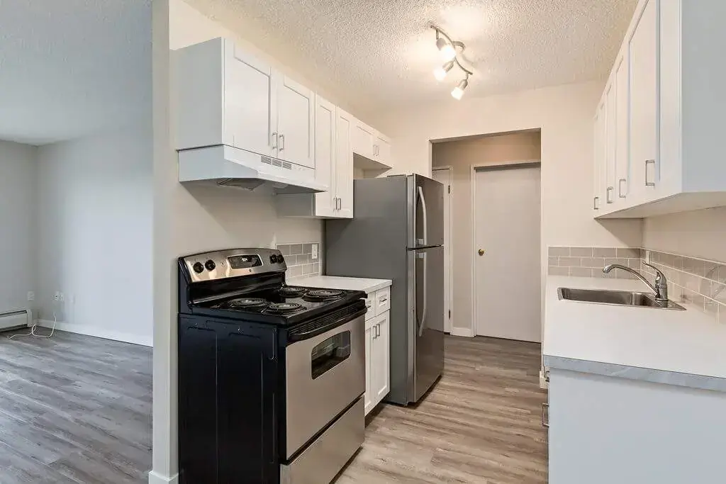 Stylish kitchen with stainless steel fridge and stove at Hillview Apartments in Medicine Hat.