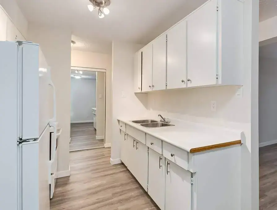 Galley style kitchen with appliances at Forest Gardens in Moose Jaw.