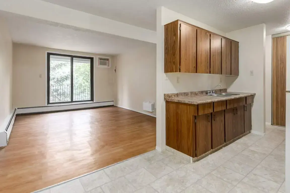 Open-concept bright living room with large windows at Forest Gardens in Moose Jaw.
