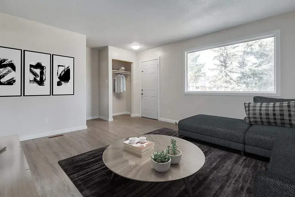 Sunlit living room with large windows at Manville Bay in Prince Albert.