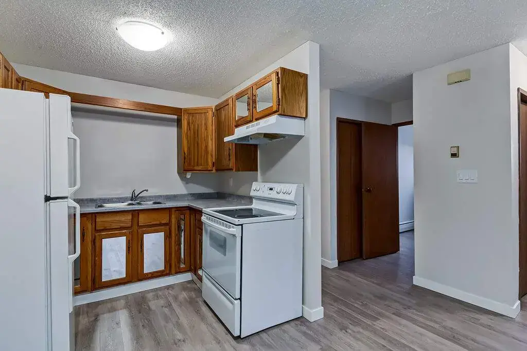 Kitchen with fridge and stove at Concord Apartments in Regina.