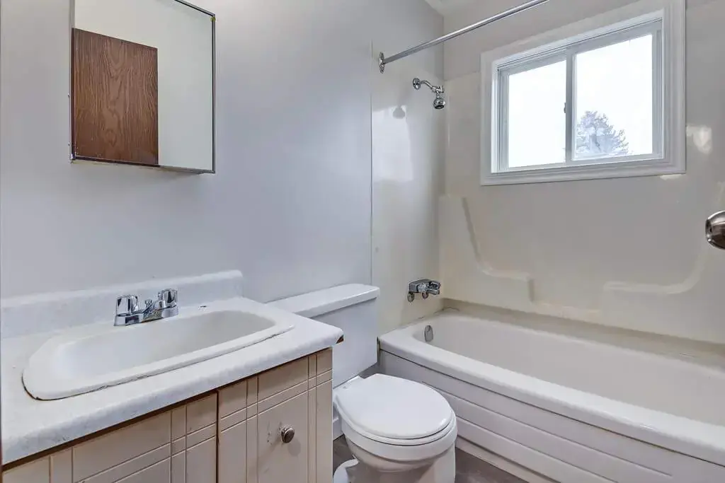 Bright full bathroom with tub and shower at Concord Apartments in Regina.