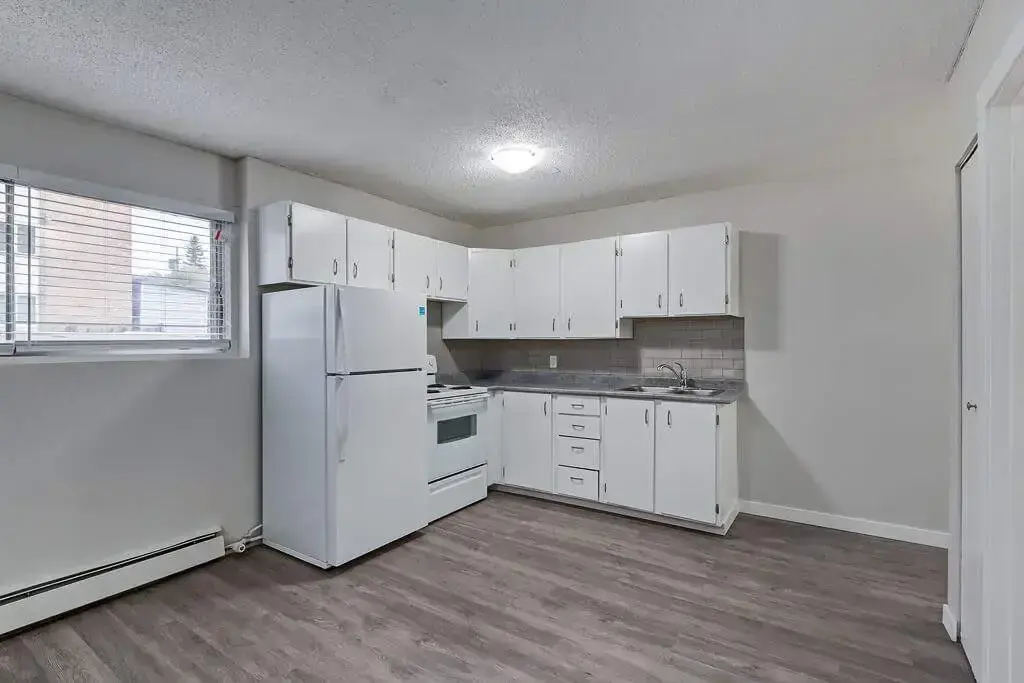 Comfortable kitchen corner with fridge and stove at Caswell Manor in Saskatoon.
