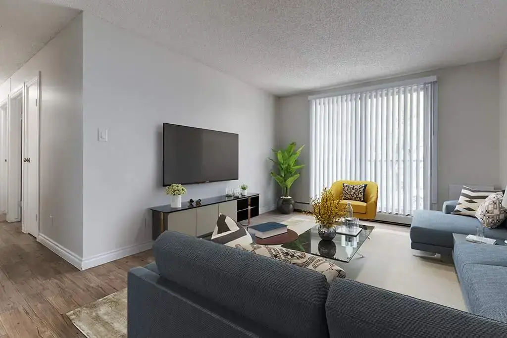 Sunlit living room with large windows at Erica Louise Manor in Saskatoon.