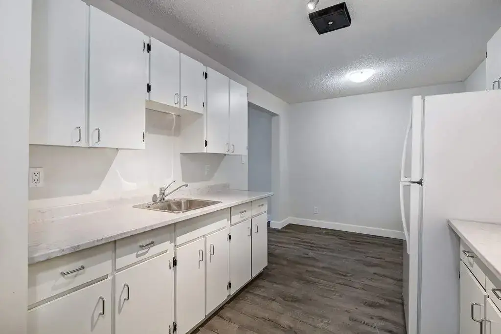 Galley style kitchen with cozy dining area at Erica Louise Manor in Saskatoon.