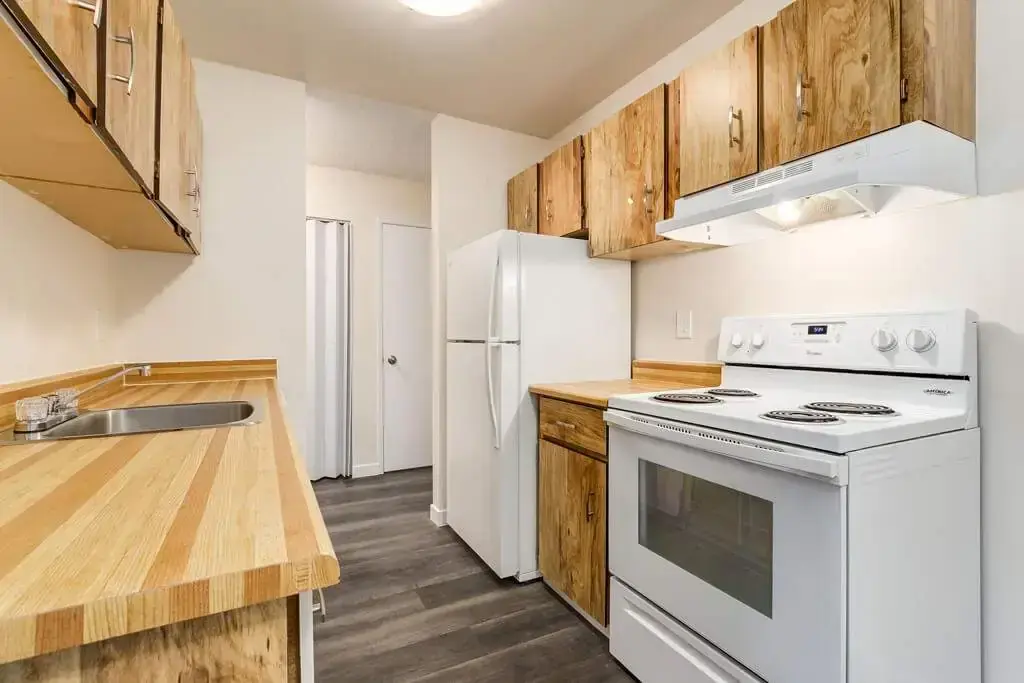Galley style kitchen with appliances at Westwind Apartments in Wetaskiwin.