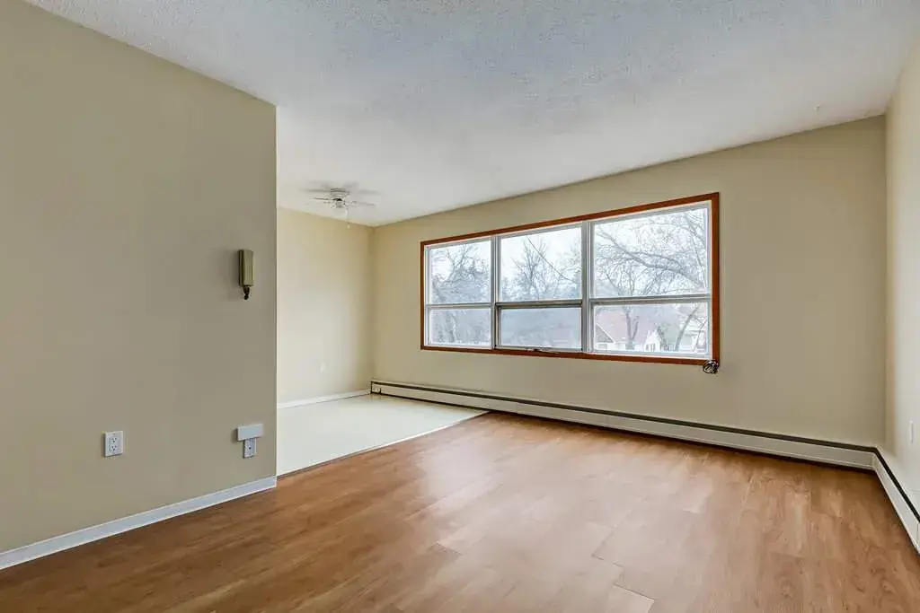Sunlit living room with large windows at Crescent Court in Yorkton.