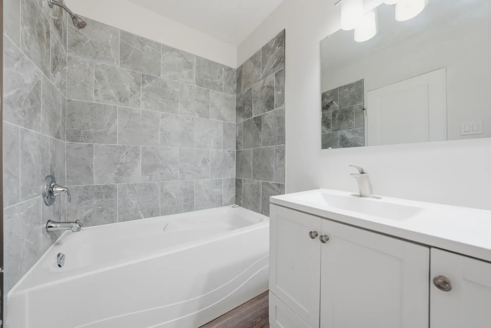 Spacious full bathroom featuring a tub and shower at Miami Apartments in Saskatoon.