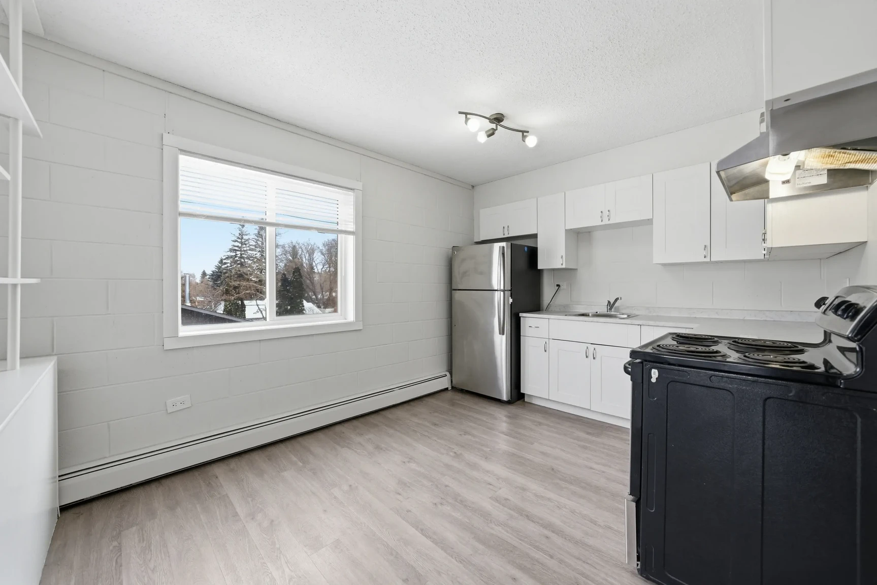 Bright modern kitchen with stainless steel appliances at Miami Apartments in Saskatoon.
