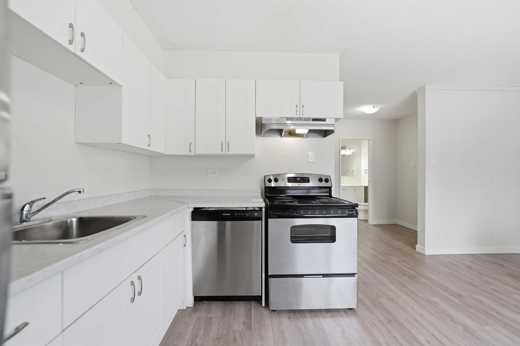 Modern kitchen with stainless steel appliances at Miami Apartments in Saskatoon.