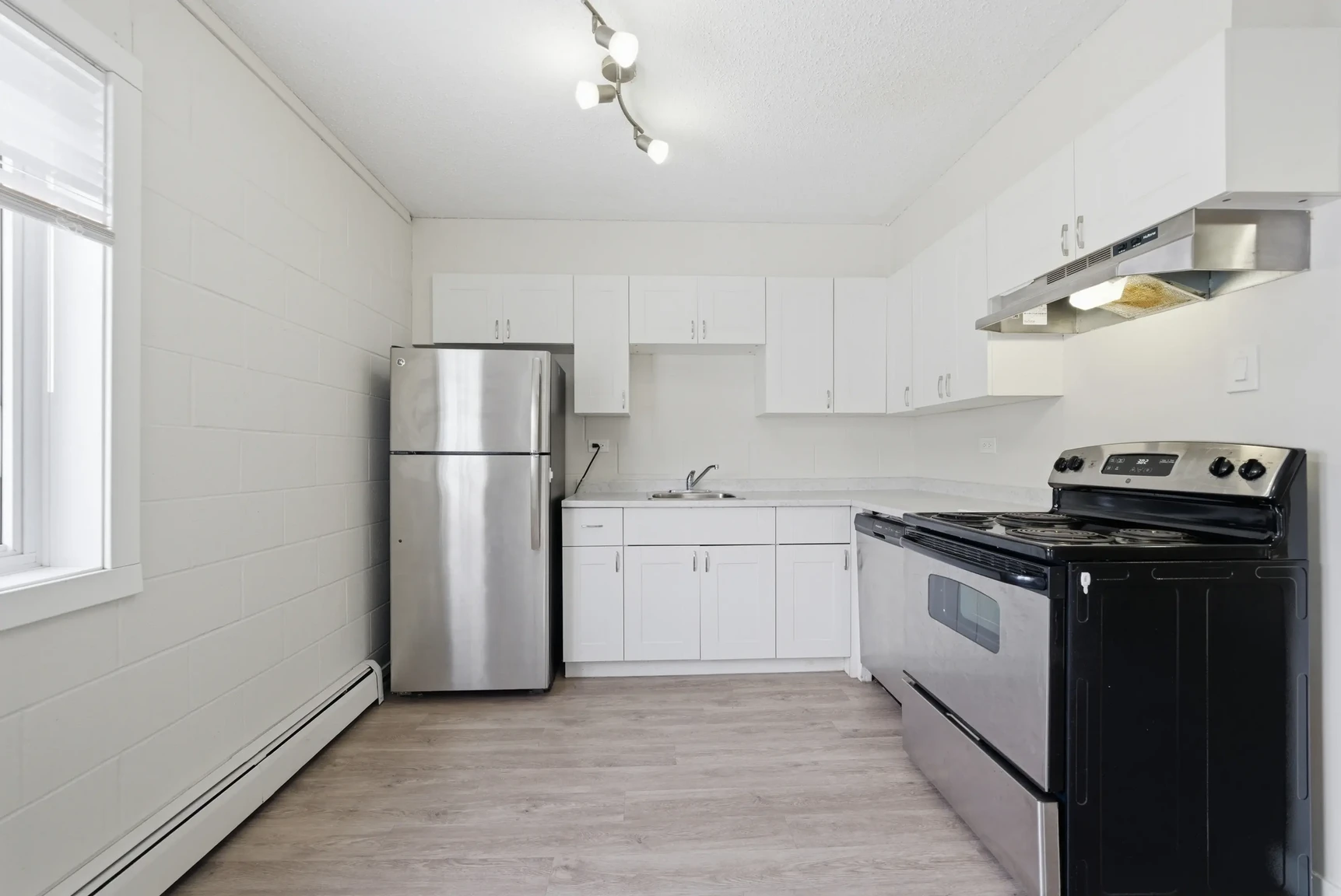 Stylish kitchen with stainless steel fridge and stove at Miami Apartments in Saskatoon.