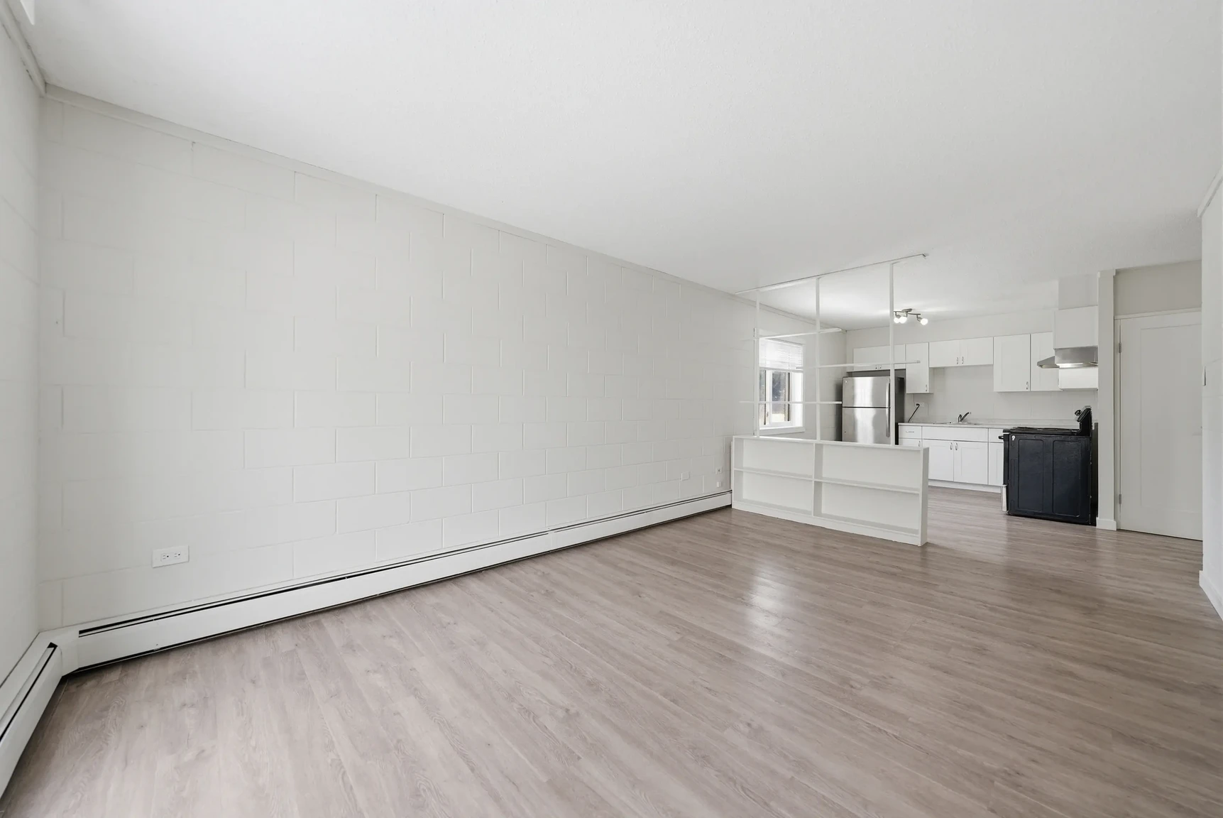 Airy living room with bright windows at Miami Apartments in Saskatoon.