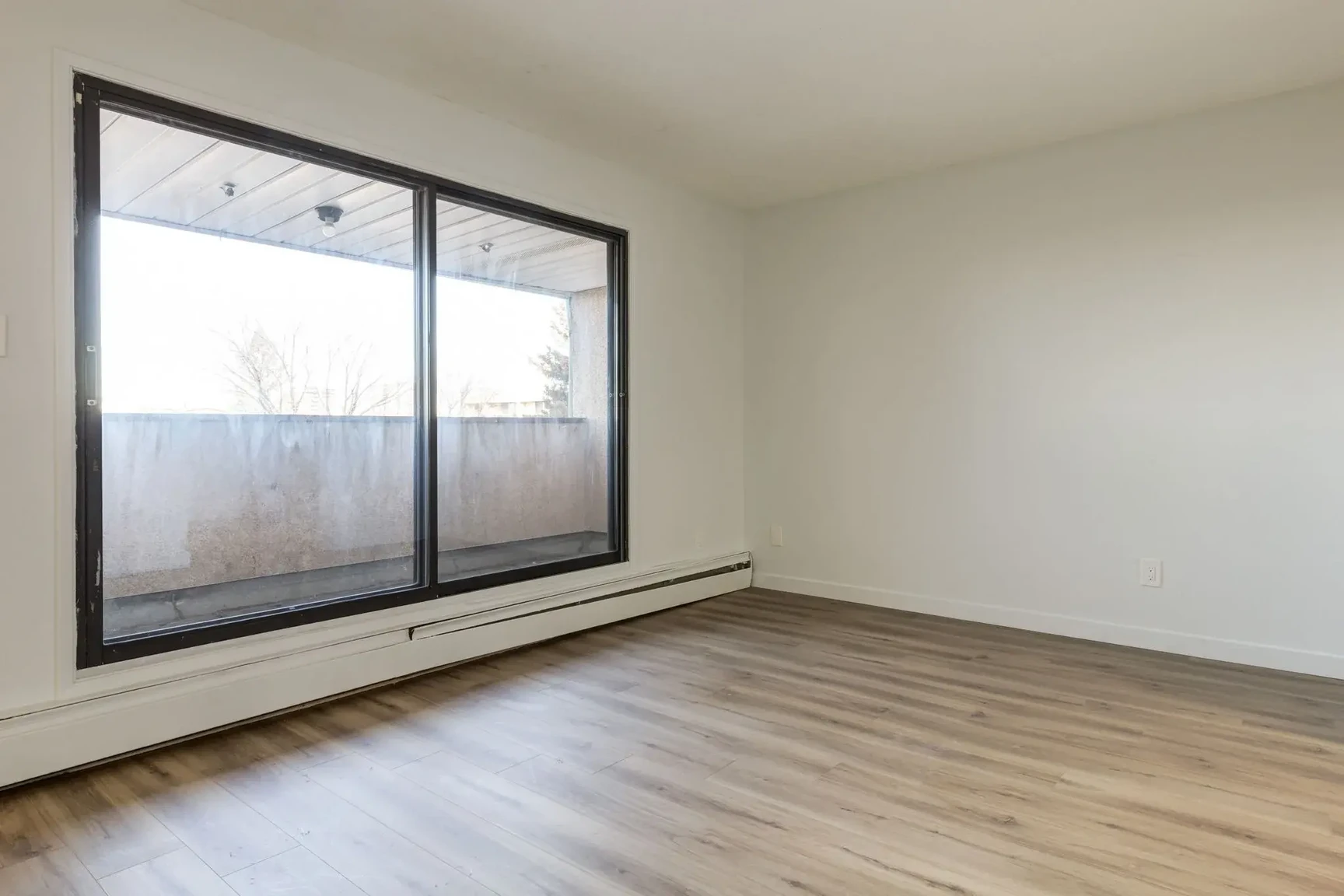 Living room with large windows and natural light at South Ridge Apartments in Edmonton.