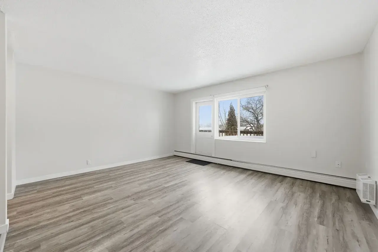 Bright living room with large windows at Thomas Manor in Prince Albert.