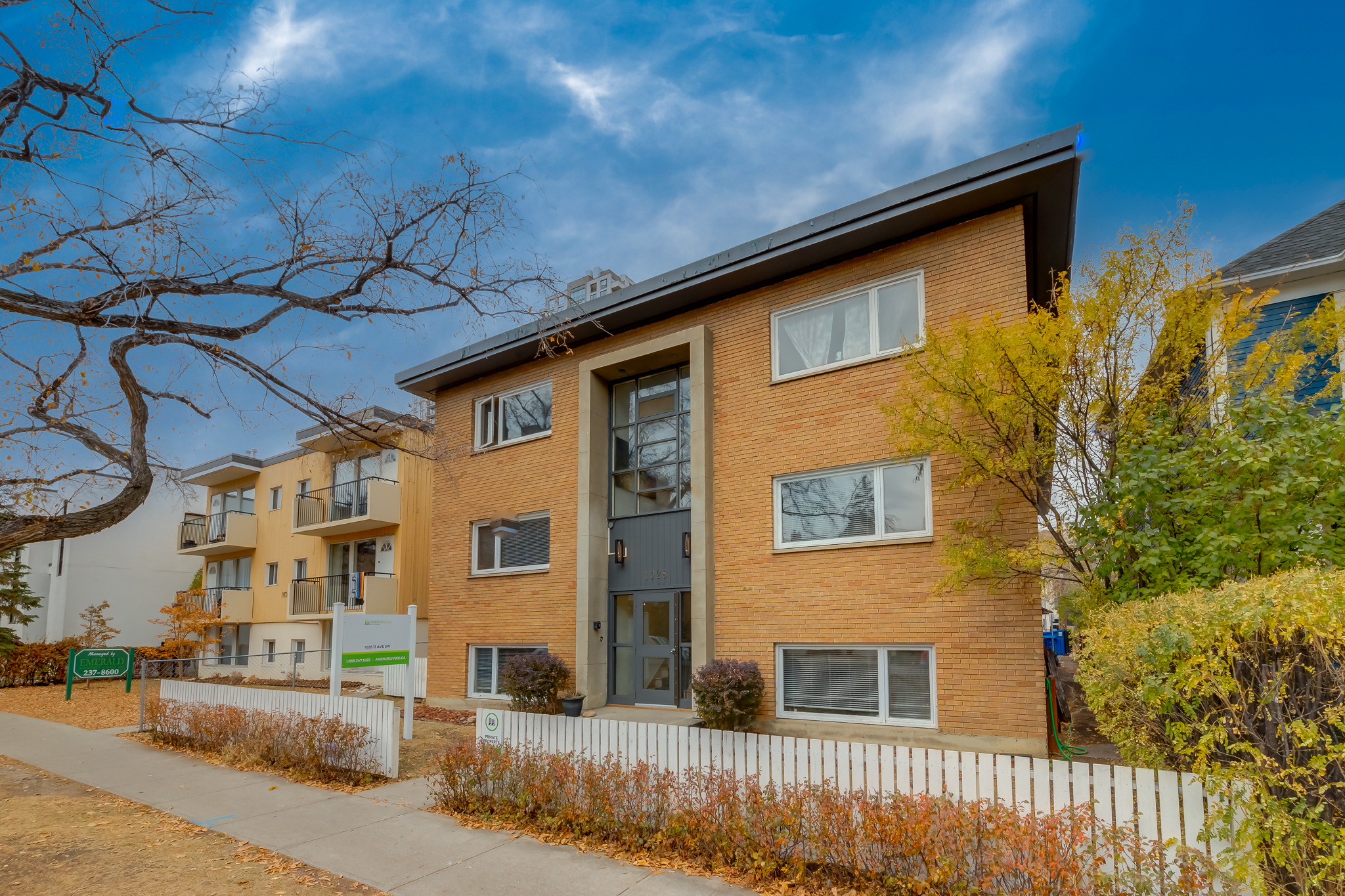 Image of apartment building surrounded by trees.