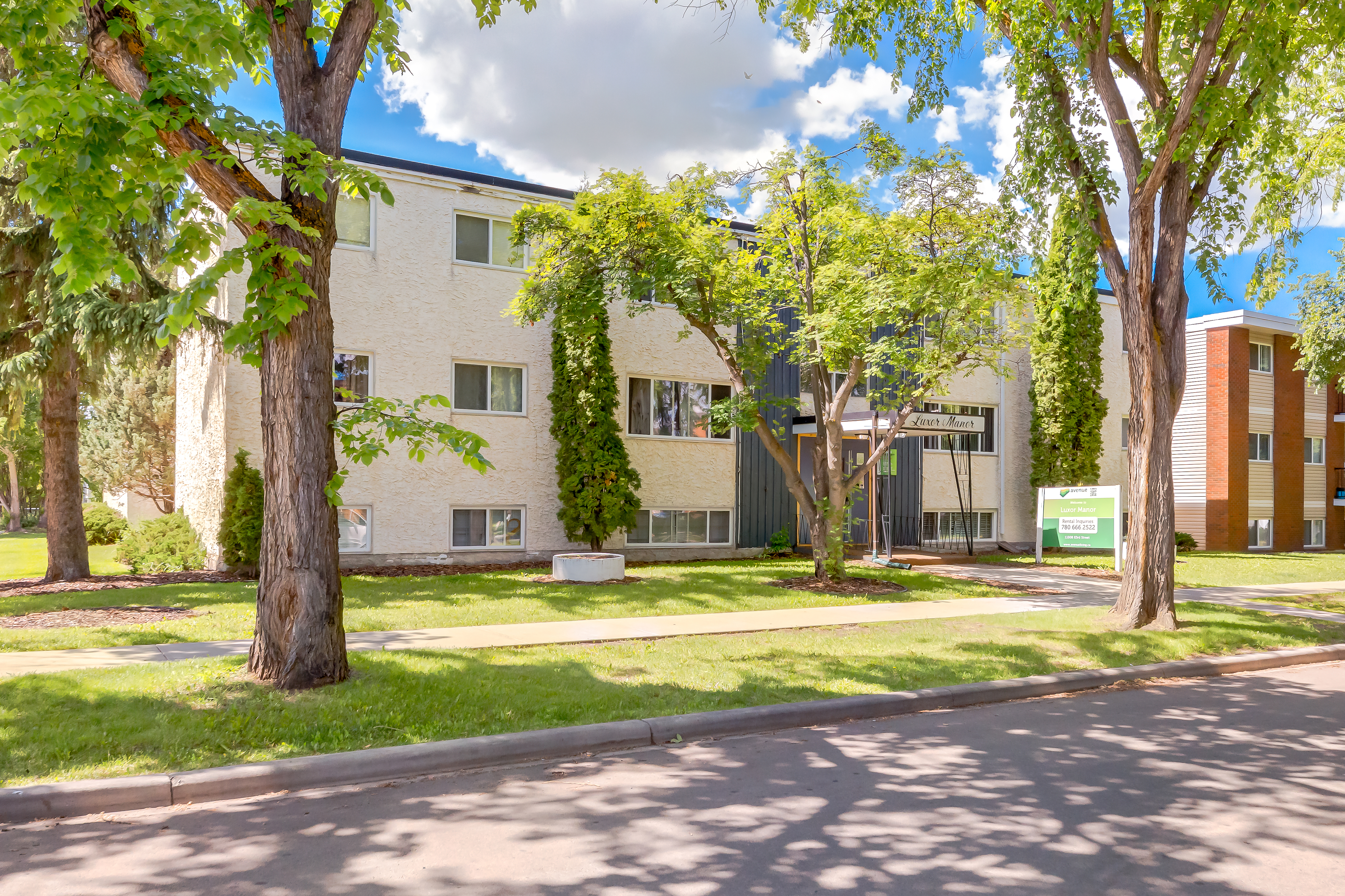 Image of apartment building surrounded by trees.
